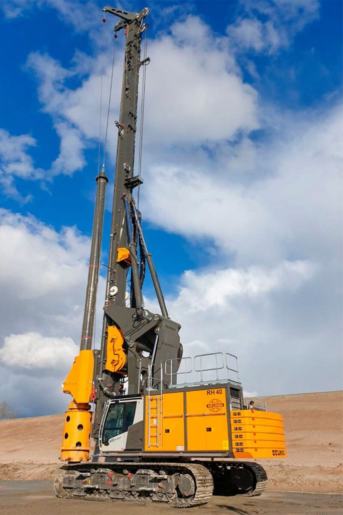 Delmag RH 40 rotary drill rig in yellow finish on a large job site